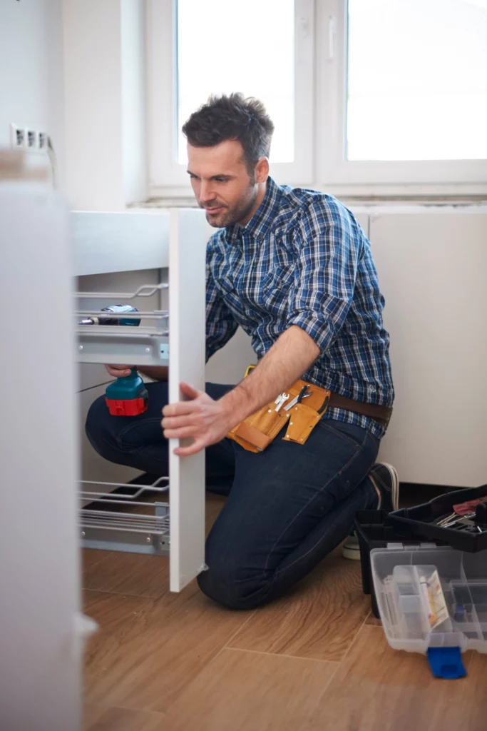 Artisan installant les meubles d'une cuisine